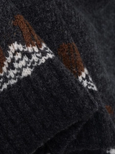 Detailed close-up of chunky dark grey knit fabric with white and brown geometric patterns