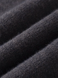 Macro detail of soft charcoal grey knit fabric texture showing high-quality fibers