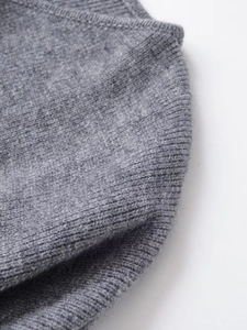 Macro view of grey knit fabric with fine stitching and ribbed cuff texture detail