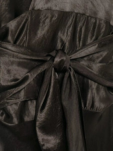 Detailed close-up of a bronze satin dress showing the fine bow-tie waist design