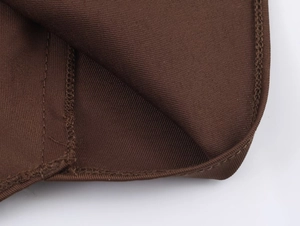 Detailed macro view of dark brown mesh fabric texture with precise stitching and hem finish