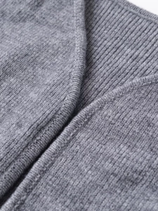 Detailed macro shot of grey ribbed knit stitching and texture on a winter sweater