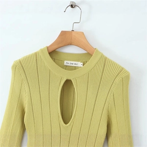 Détail d'une robe en tricot vert citron avec découpe en goutte d'eau et étiquette