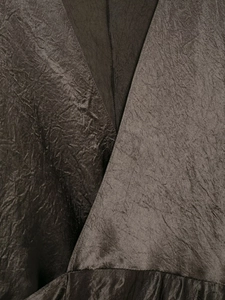 Detail of V-neck satin dress with pleated texture and metallic bronze finish