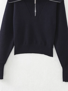 Dettaglio maglione blu scuro in maglia con mezza zip e colletto alto a costine