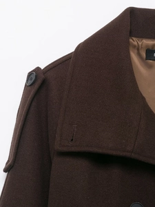 Détail d'un manteau en laine marron avec revers larges, épaulettes boutonnées et doublure lisse