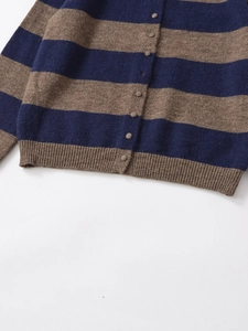 Dettaglio di un cardigan in maglia a righe larghe in lana blu scuro e marrone