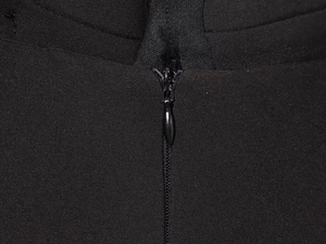 Détail du zip invisible fluide sur le côté d'un vêtement noir en tissu sergé chic