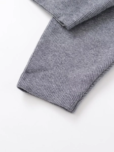 Detail of grey knitted sleeve cuff featuring high-quality ribbed texture and soft fabric
