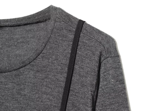 Détail du haut en maille grise avec col rond et sangle noire sur textile doux