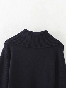 Primo piano della trama in maglia a coste e del dettaglio del colletto di questo maglione blu