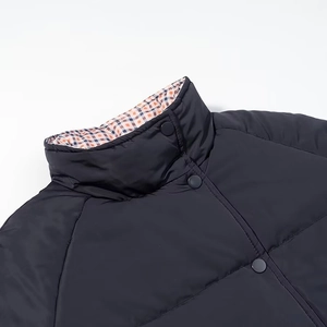 Detail view of high collar jacket with navy fabric, snap buttons and checkered lining