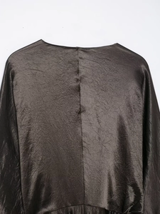 Detailed close-up showing the metallic pleated satin texture of this elegant bronze V-neck dress