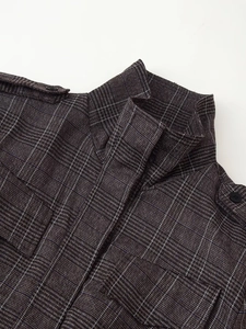 Close-up of winter plaid jacket collar featuring epaulettes and detailed button fasteners