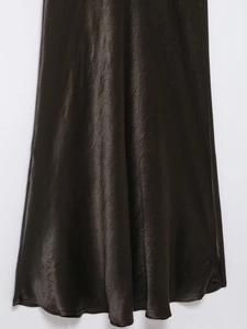 Detail of silk satin fabric texture and drape of a long brown evening dress