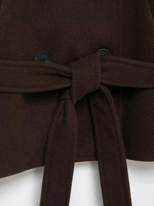 Détail d'un manteau en laine marron foncé montrant la ceinture et les boutons noirs