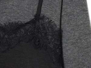 Détail de robe en maille gris foncé avec dentelle de cils noire délicate et fines bretelles