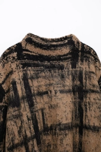 Close-up of brown and black plaid knit fabric with soft mohair texture and fibers