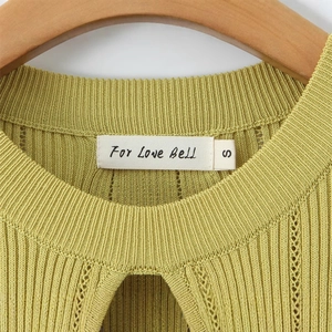 Gros plan du décolleté de la robe en maille côtelée vert citron avec étiquette de marque