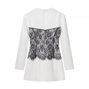 Detail of the back featuring black floral lace patchwork and hidden zipper on white dress