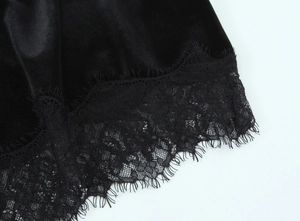 Gros plan sur tissu en velours noir avec bordure en dentelle cil sur jupe asymétrique