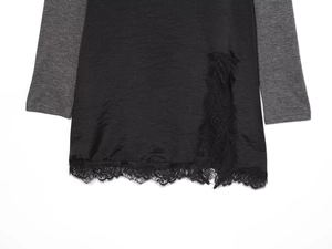 Détail de robe noire avec dentelle complexe et manches grises contrastées