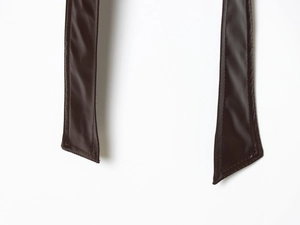 Close-up of brown faux leather belt with reinforced stitching and clean angled cut ends