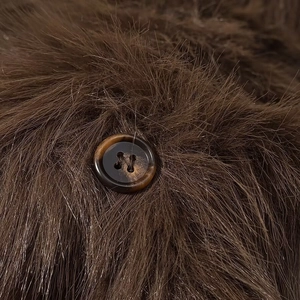 Detailed macro shot of brown faux fur texture with a tortoiseshell pattern button