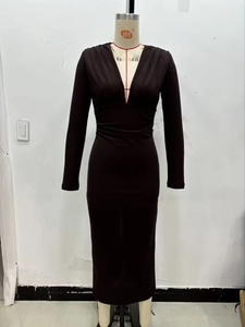 Détail d'une robe à manches longues, col en V, plis à la taille et coupe ajustée