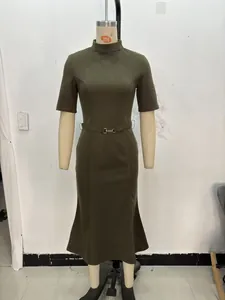 Detail of dark green knit dress featuring a high neck and waist belt with metal buckle