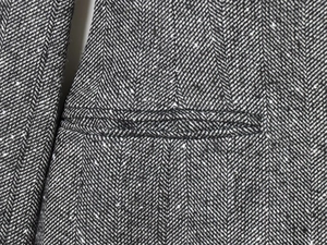 Detail shot of grey herringbone fabric showing the welt pocket and premium sewing