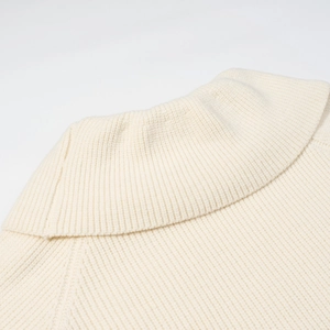 Dettaglio della trama a costine su maglione bianco a collo alto con cuciture pregiate