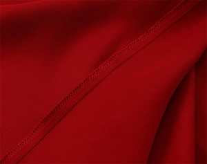 Macro view showing high-quality stitching and seam detail of the red satin long dress