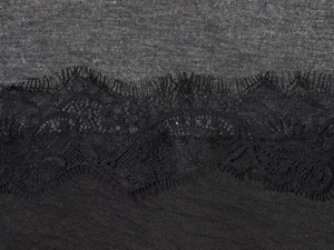 Gros plan sur un tissu en maille gris foncé avec des détails de dentelle de cils noirs