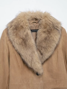 Detailed close-up of the plush faux fur collar and brand label on a camel suede coat