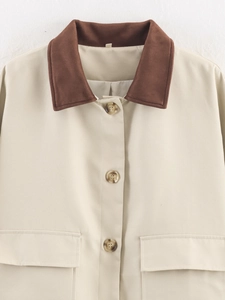 Detail of beige jacket showing contrasting brown suede collar and tortoiseshell buttons