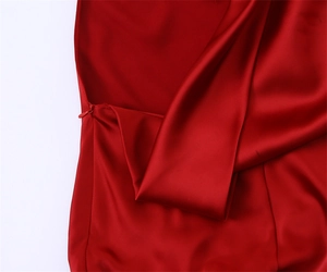 Detailed close-up of smooth red satin fabric with a high-quality invisible side zipper