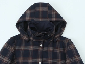 Detail view of plaid hooded jacket with high collar and metal snap buttons
