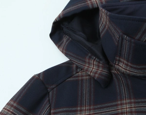 Detailed macro view of the navy blue plaid fabric and stitching on hood and collar