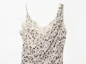 Détail de la dentelle et du motif à pois gris sur une robe blanche élégante