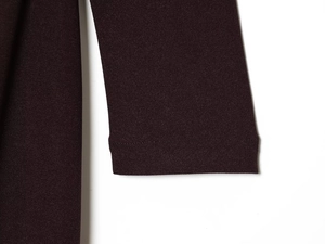 Détail du tissu de la robe bordeaux à col en V montrant la couture de qualité