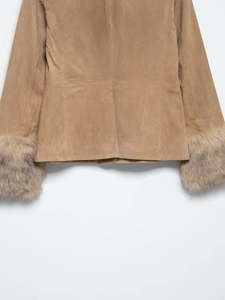 Detail view of khaki suede coat featuring plush faux fur cuffs and back hem vent design