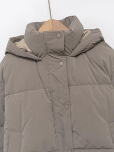 Detail view of taupe padded jacket featuring snap-button collar and quilted texture