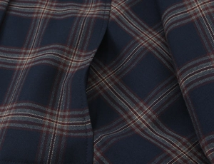 Macro detail of navy blue and brown plaid fabric texture with fine stitching on jacket