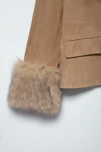 Detail of camel faux suede jacket featuring fuzzy faux fur cuffs and flap pocket stitching