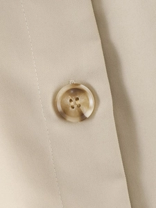 Macro shot of an amber texture button on a khaki twill trench coat with precision stitching