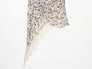 Détail du tissu léger avec motifs à pois irréguliers et bordure en dentelle blanche délicate