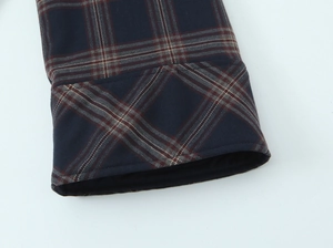 Detail view of navy blue plaid jacket cuff featuring textured twill fabric and stitching
