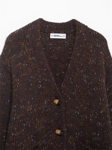 Detail of dark brown speckled knit cardigan featuring V-neck and horn-style buttons