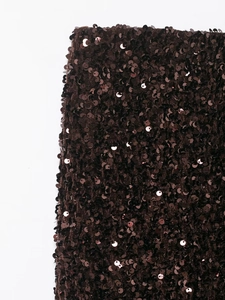 Close-up of shimmering dark coffee sequins on a mermaid midi skirt with metallic finish